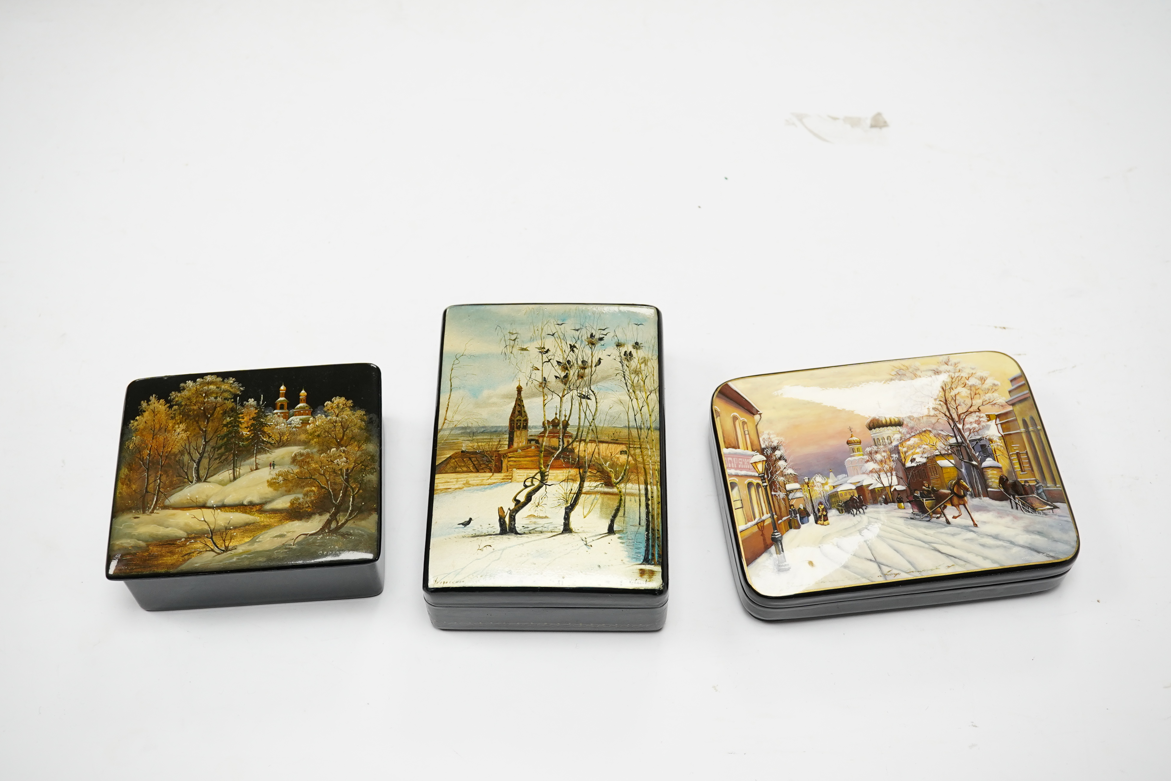 Three late 19th/early 20th century Russian lacquer boxes, decorated with snow scenes, largest 13.5cm. Condition - good